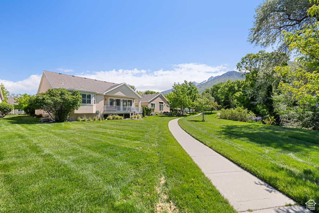 View of front of property with a front lawn, stucco siding, and a mountain view