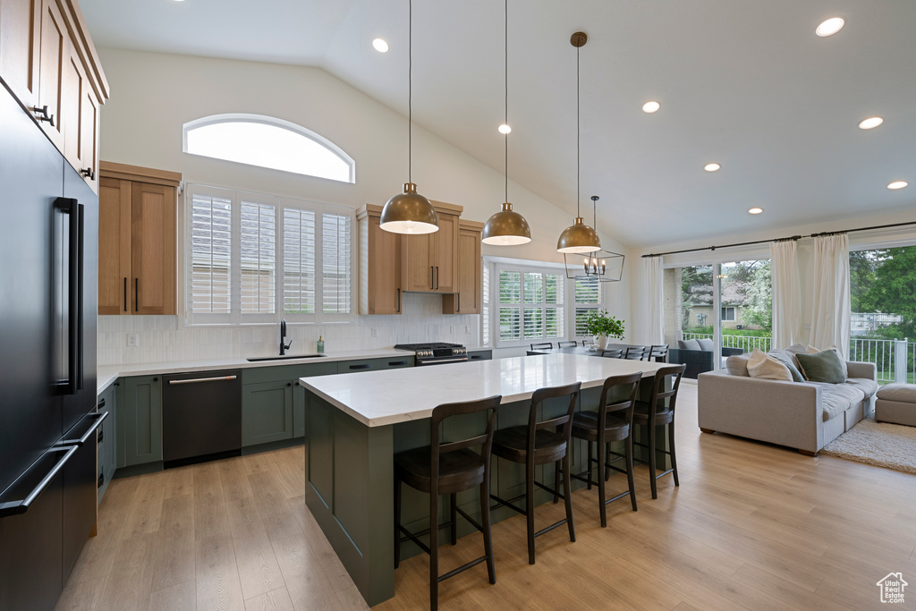 Kitchen featuring high quality fridge, dishwashing machine, plenty of natural light, decorative backsplash, and recessed lighting