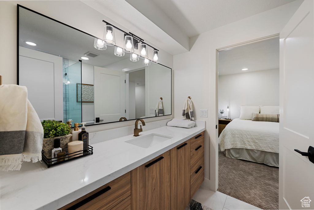 Ensuite bathroom featuring a stall shower, vanity, tile patterned floors, and recessed lighting