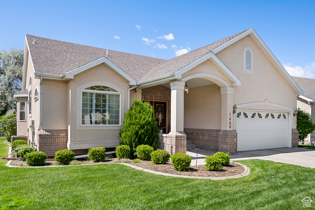 Single story home featuring concrete driveway, roof with shingles, a front lawn, and a garage