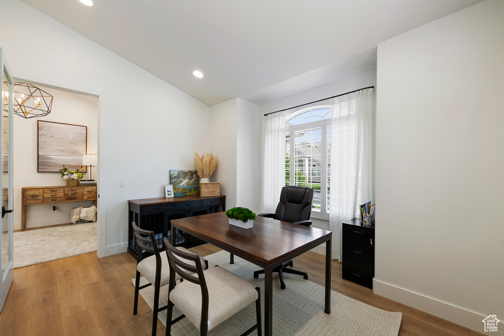 Office space featuring light wood-style floors, vaulted ceiling, baseboards, recessed lighting, and a chandelier