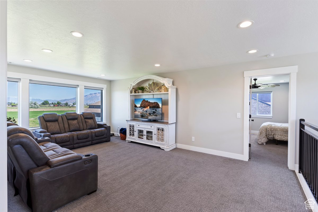 Carpeted living area with recessed lighting, baseboards, and a ceiling fan