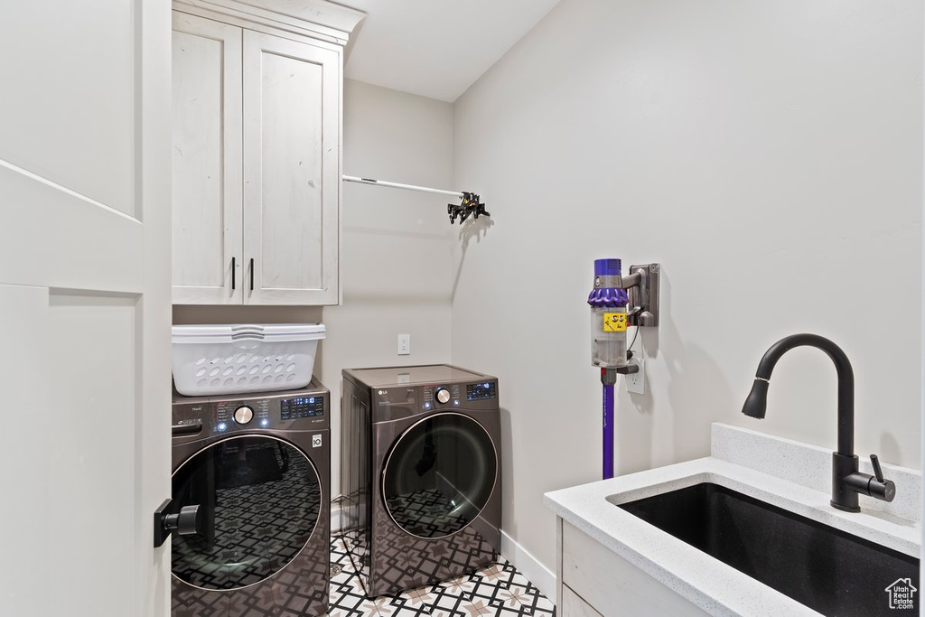 Washroom featuring cabinet space, washer and clothes dryer, and baseboards