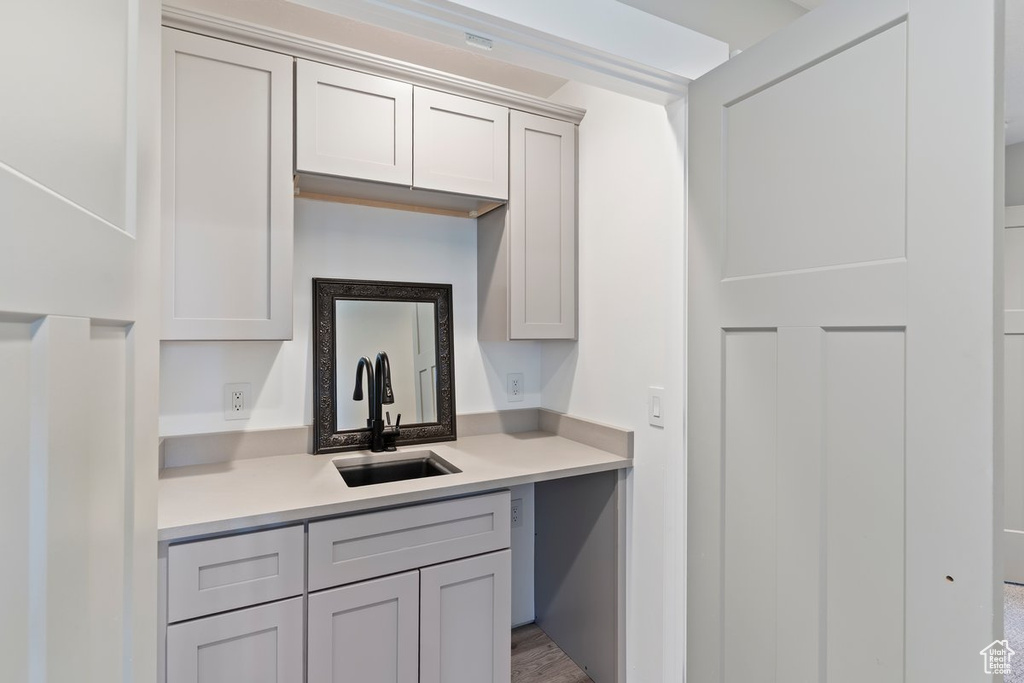 Kitchen with a sink, light countertops, and gray cabinetry