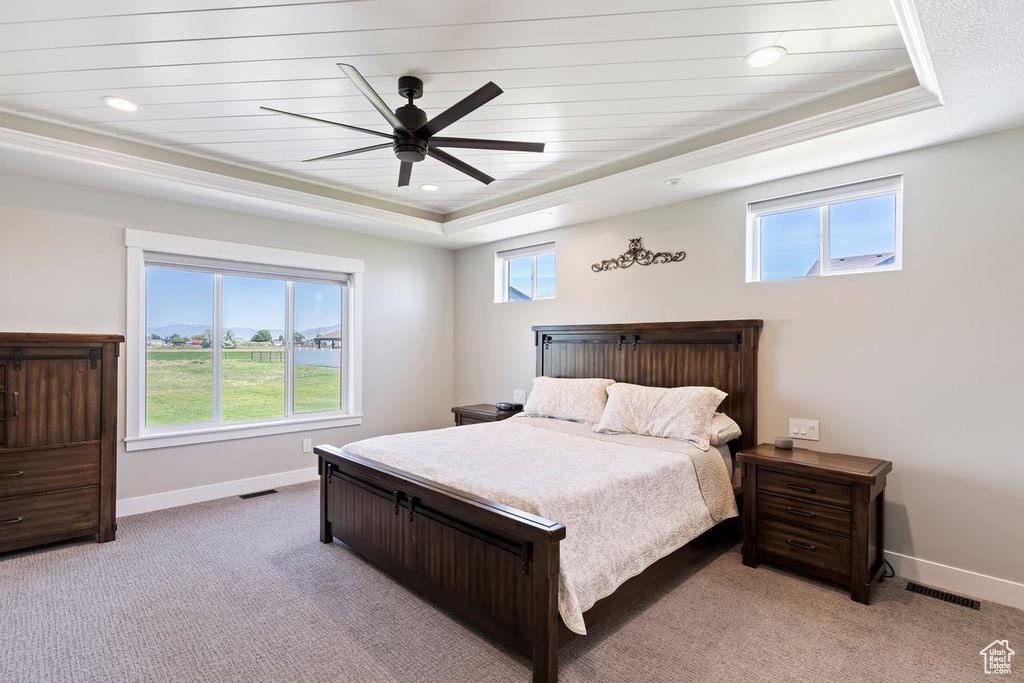 Bedroom with a raised ceiling, baseboards, light colored carpet, and recessed lighting