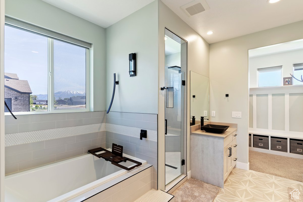 Bathroom with vanity, healthy amount of natural light, a garden tub, a stall shower, and recessed lighting