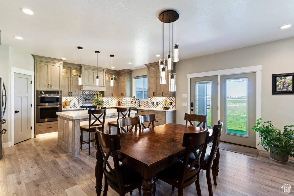 Dining space with light wood-style floors and recessed lighting