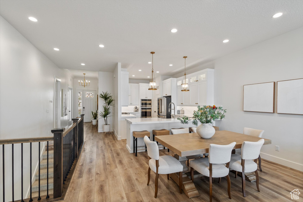 Dining room featuring a chandelier, recessed lighting, light wood finished floors, and baseboards