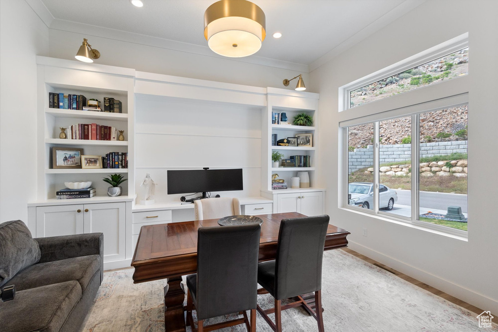 Office space featuring ornamental molding, baseboards, and light wood-style flooring