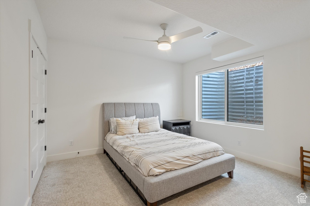 Carpeted bedroom featuring baseboards and a ceiling fan