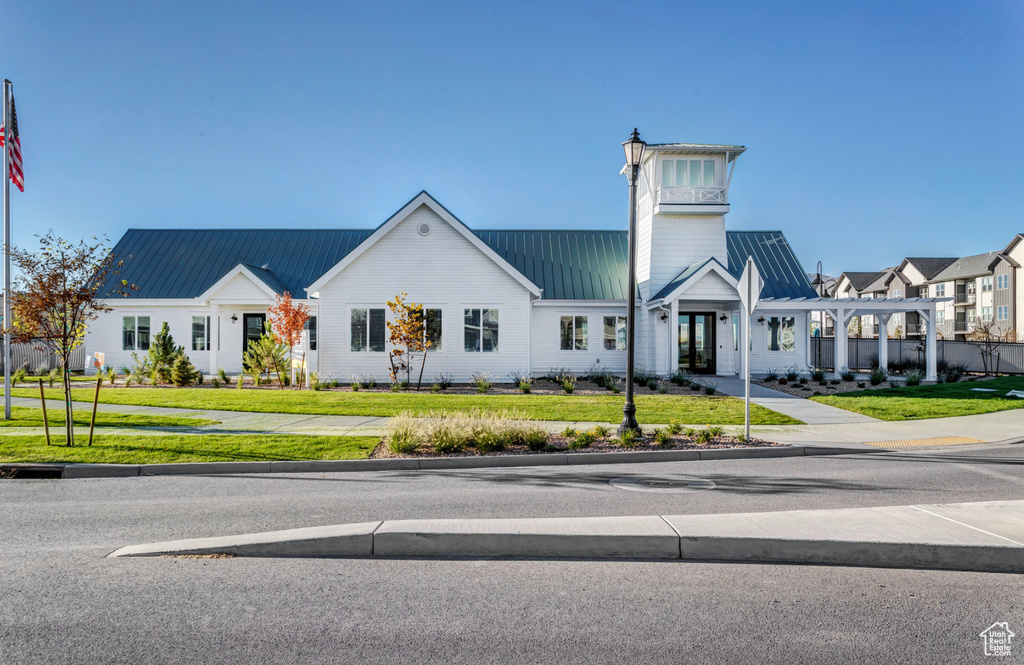 View of front of property with metal roof and a front lawn