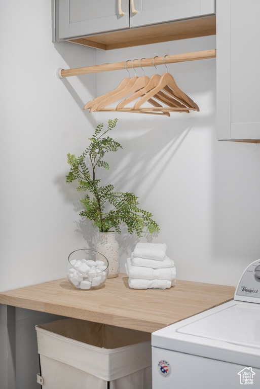 Washroom featuring cabinet space and washer / dryer