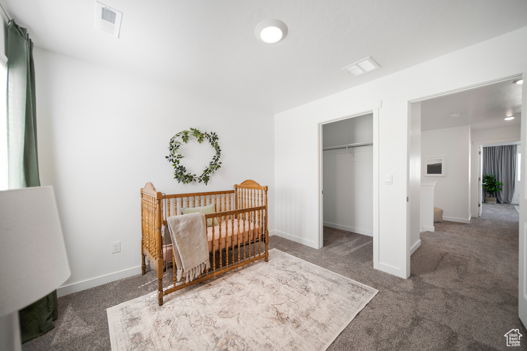 Bedroom with carpet floors, baseboards, visible vents, and a closet