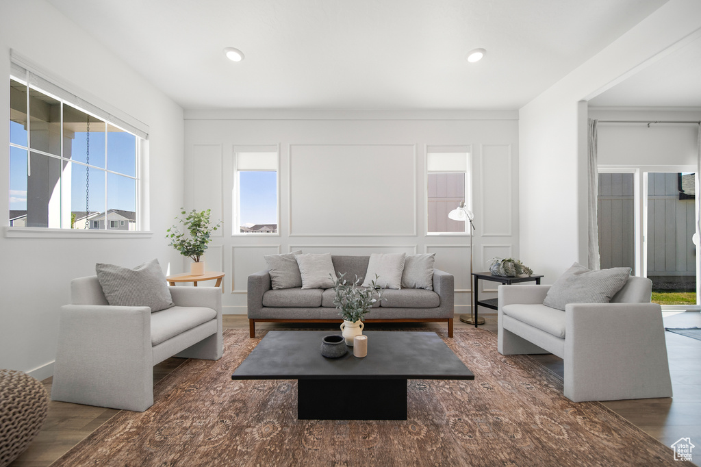 Living area with a decorative wall, recessed lighting, and wood finished floors