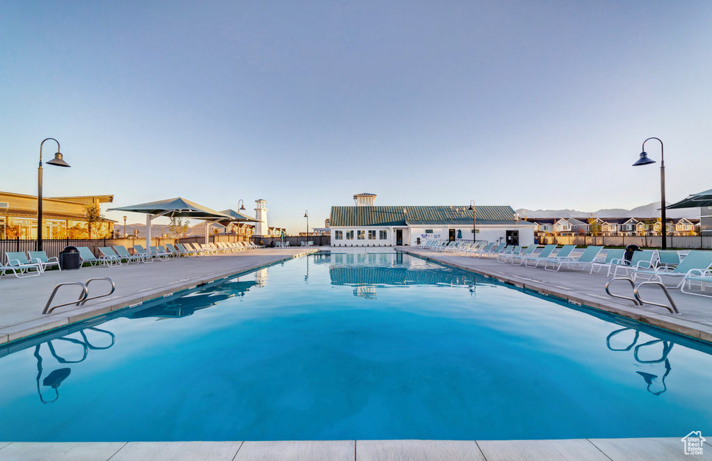 Community pool featuring fence, a patio, and a residential view