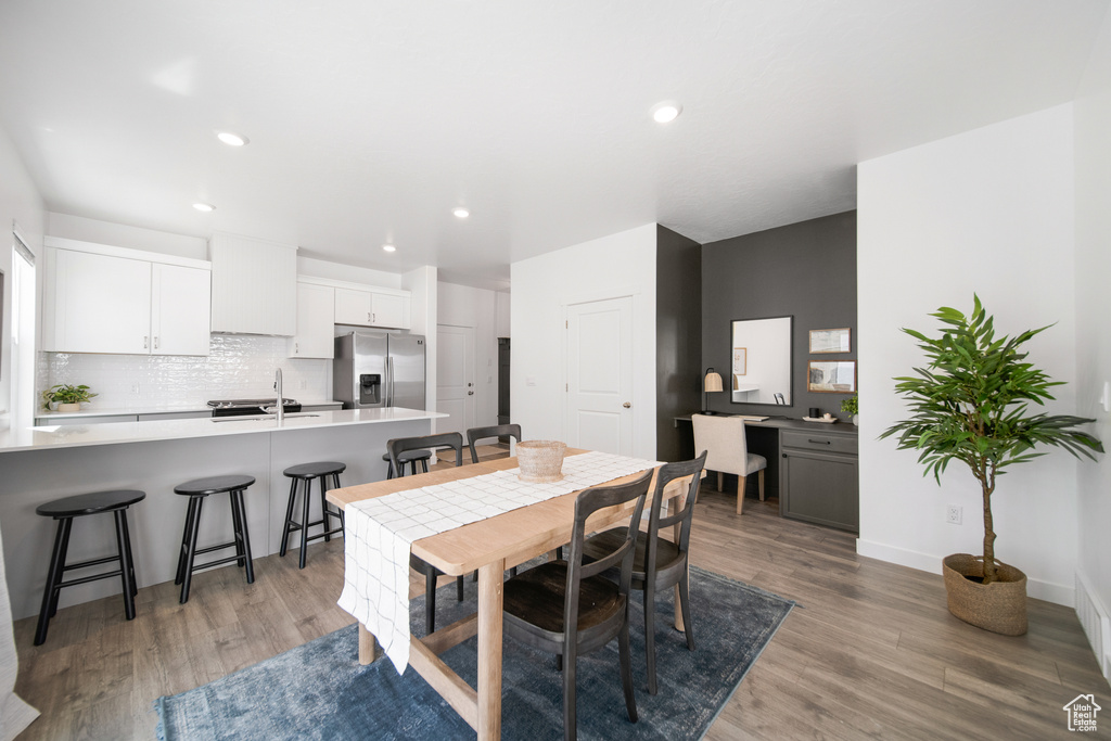 Dining space with baseboards, recessed lighting, and light wood-style flooring
