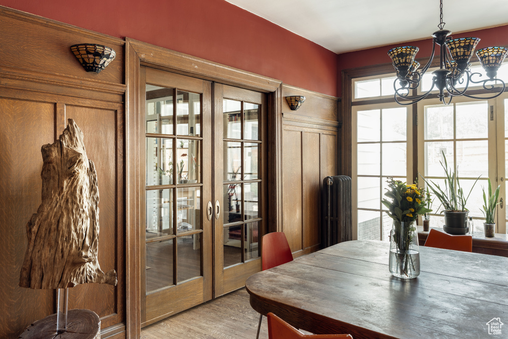Dining area featuring french doors, light wood-style floors, and a chandelier
