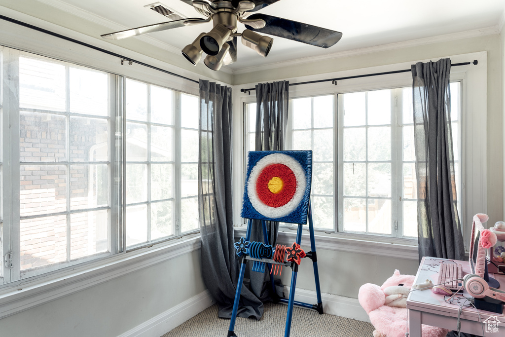 Carpeted office space featuring baseboards, ornamental molding, and a ceiling fan