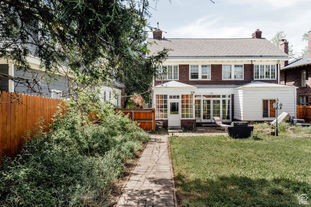 Rear view of house with a chimney and a sunroom