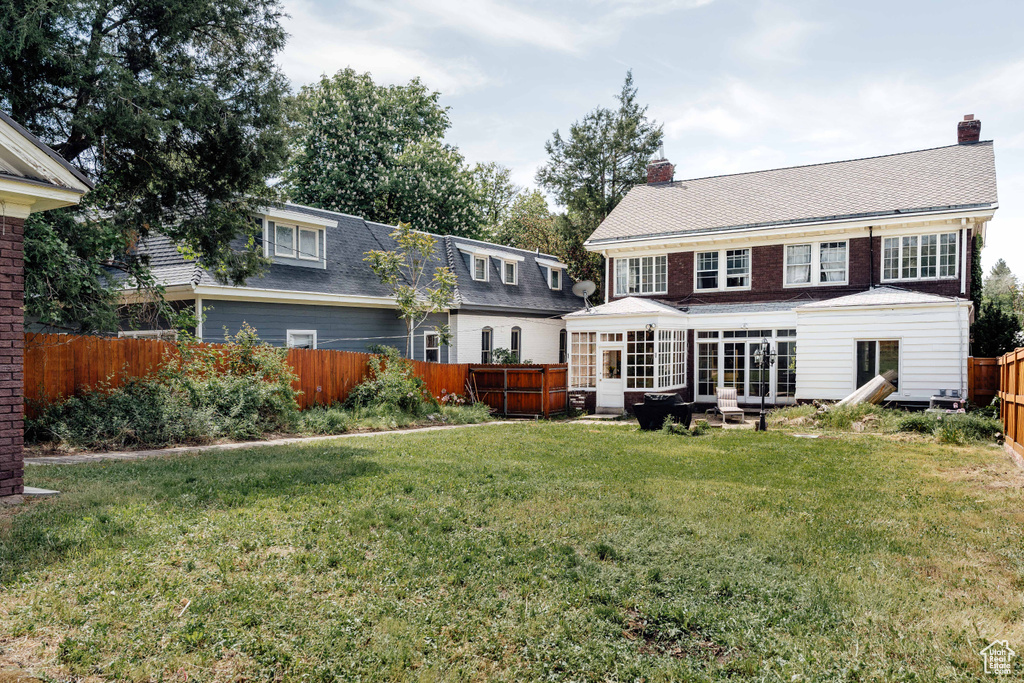 Back of property with a chimney and a hot tub