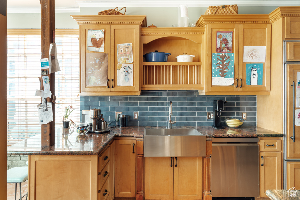 Kitchen with dishwasher, a sink, ornamental molding, tasteful backsplash, and glass insert cabinets