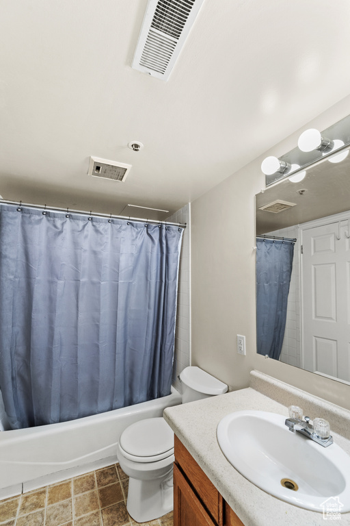 Bathroom featuring shower / bath combo with shower curtain, toilet, and vanity