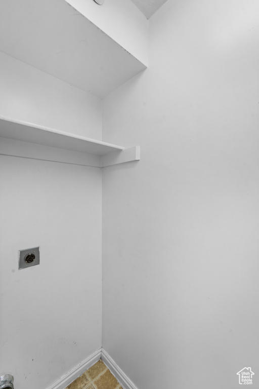 Clothes washing area featuring hookup for an electric dryer and baseboards