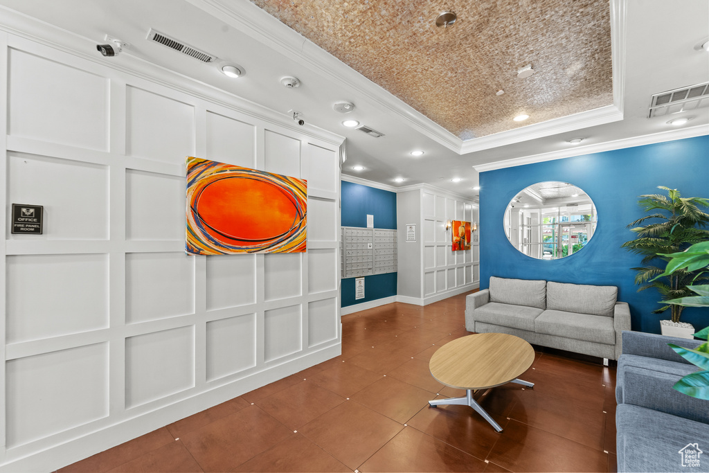 Sitting room with a raised ceiling, ornamental molding, baseboards, recessed lighting, and tile patterned flooring
