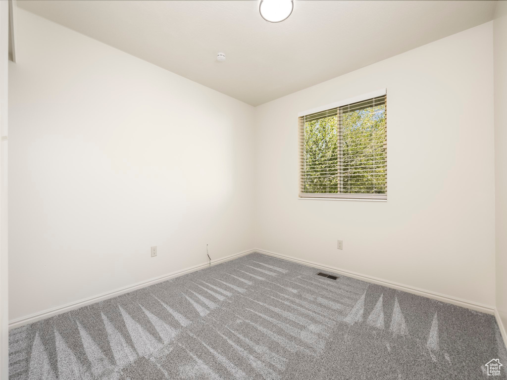 Unfurnished room featuring carpet and baseboards
