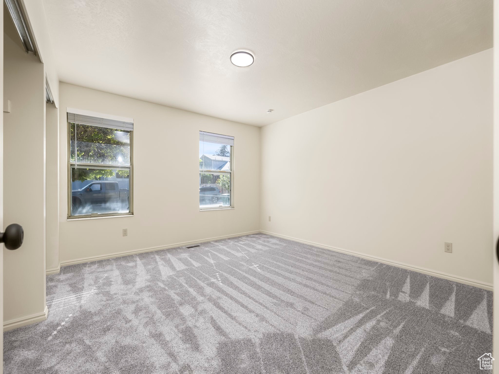 Carpeted empty room featuring baseboards