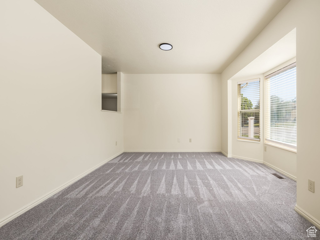 Unfurnished room with carpet and baseboards