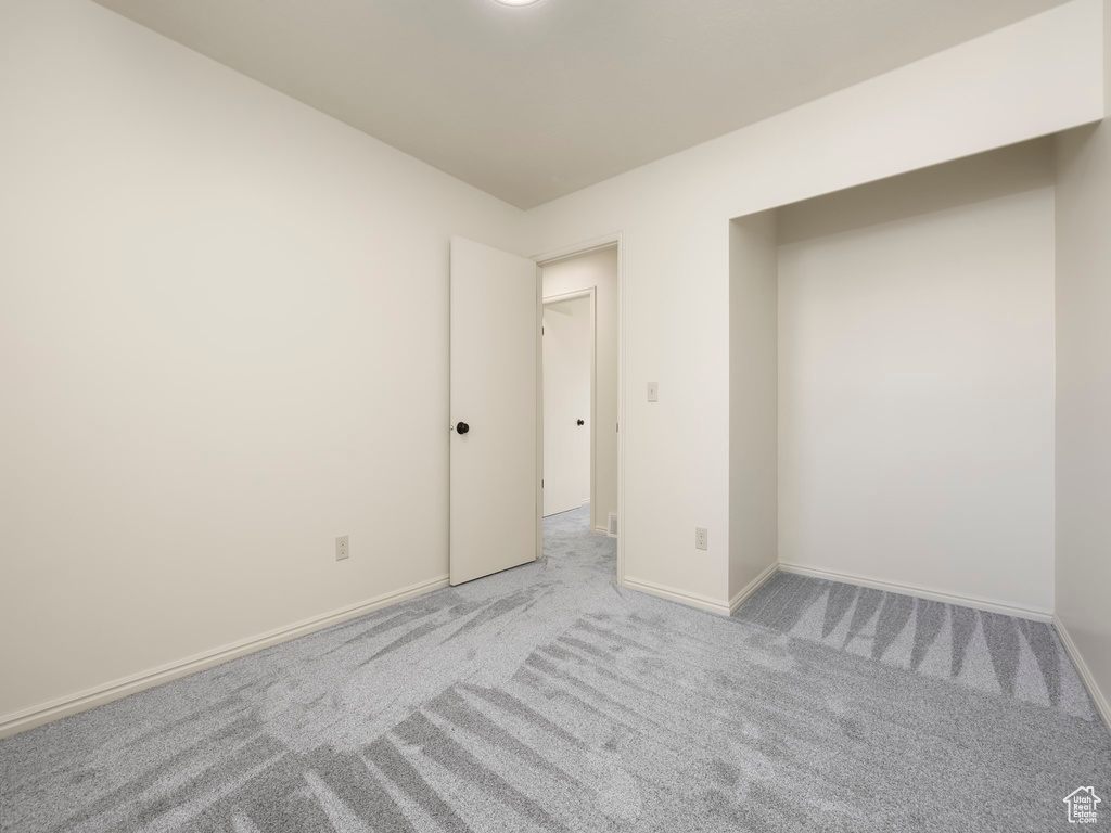 Spare room with light carpet and baseboards
