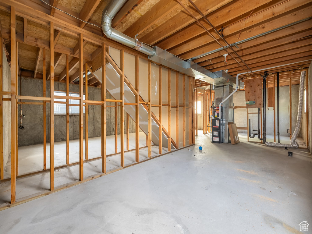 Unfinished below grade area featuring heating unit