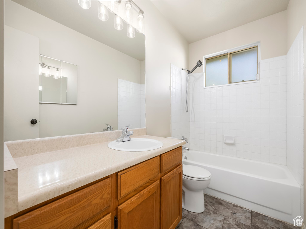 Bathroom featuring vanity,  shower combination, and toilet