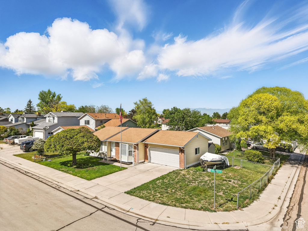 Ranch-style house featuring a residential view, a garage, brick siding, and driveway