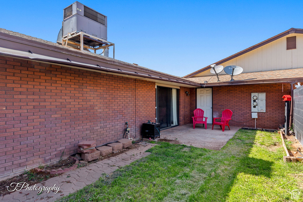 View of grassy yard with a patio area