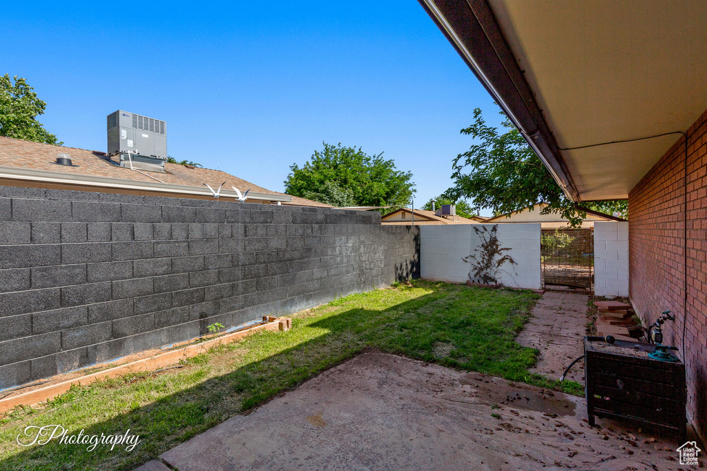 Fenced backyard with central AC, a patio, and an outbuilding