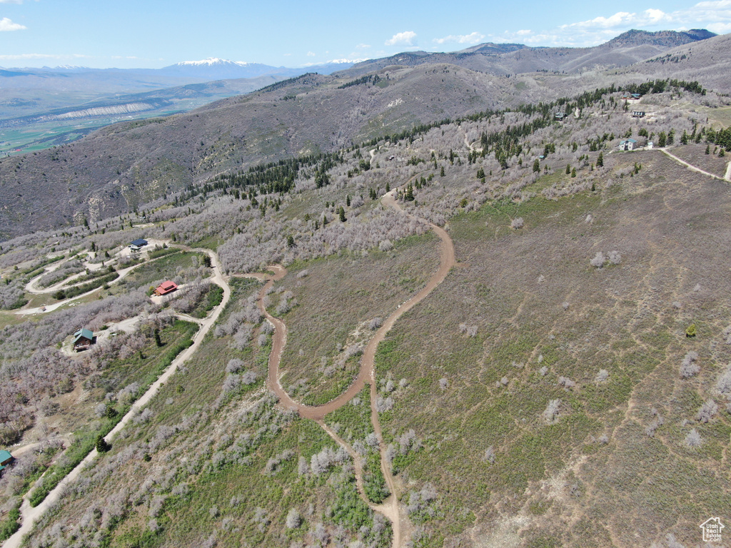 Aerial view of property and surrounding area featuring a mountain backdrop