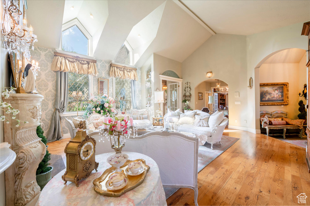 Living area featuring arched walkways, plenty of natural light, and wood finished floors