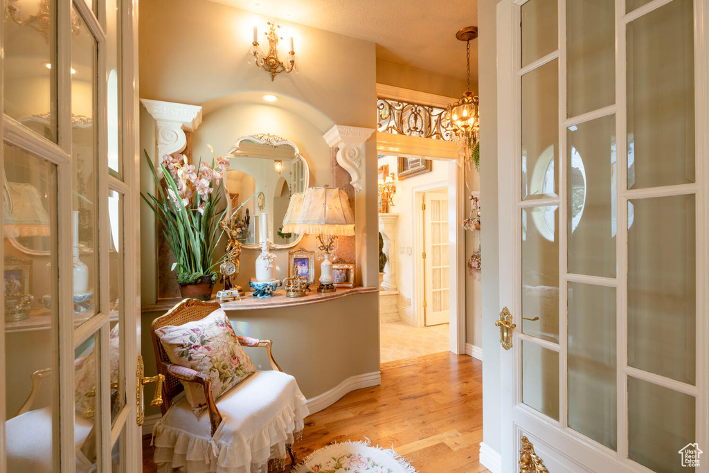 Interior space featuring baseboards, wood finished floors, and an inviting chandelier