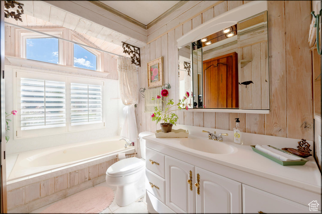Bathroom with wood walls, tiled tub, vanity, and toilet