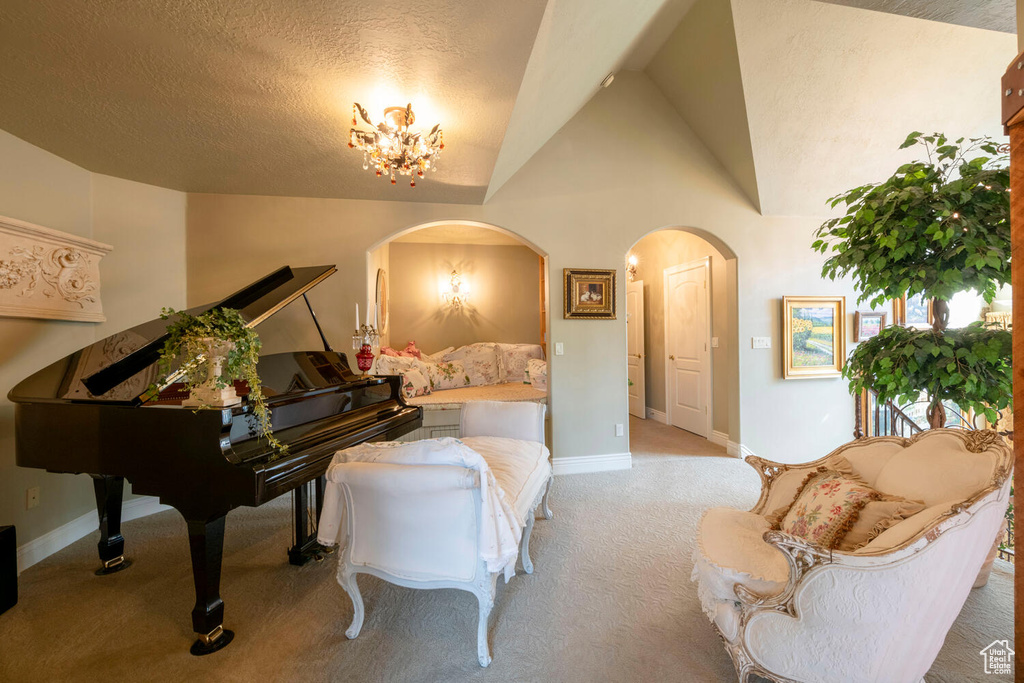 Living area with arched walkways, carpet, lofted ceiling, and baseboards