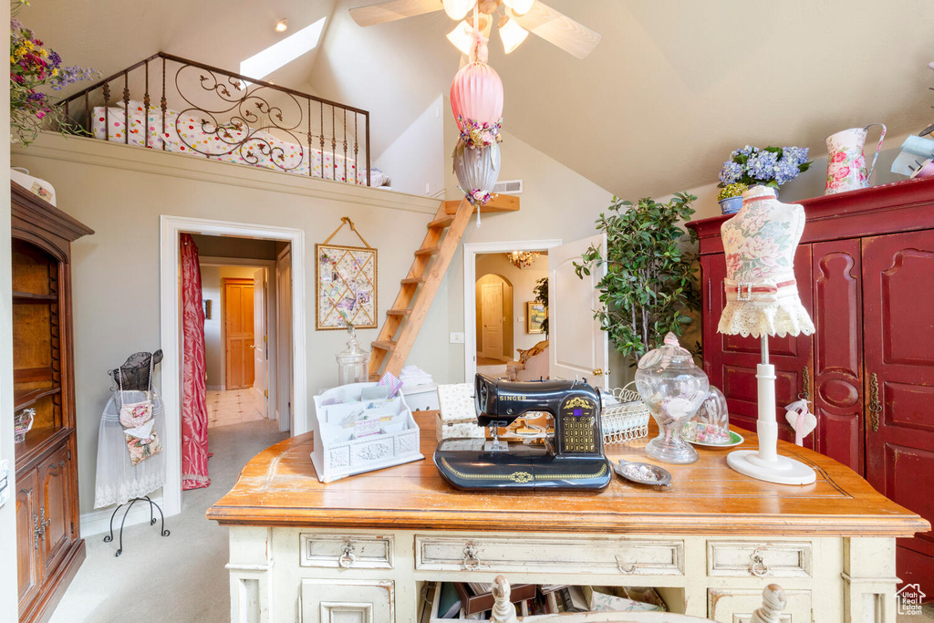 Interior space with high vaulted ceiling, light colored carpet, ceiling fan, and visible vents
