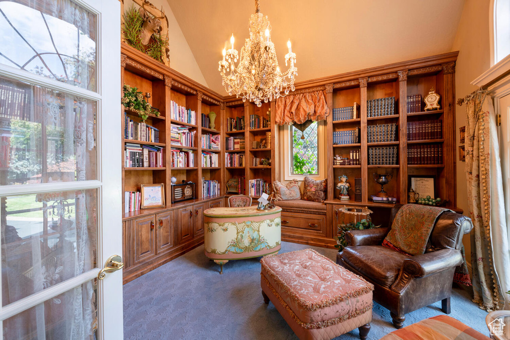 Sitting room featuring an inviting chandelier, vaulted ceiling, and carpet flooring