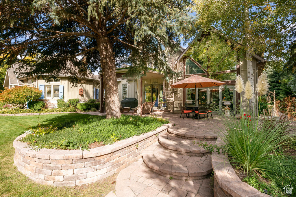 Back of property with board and batten siding, a patio area, and a lawn