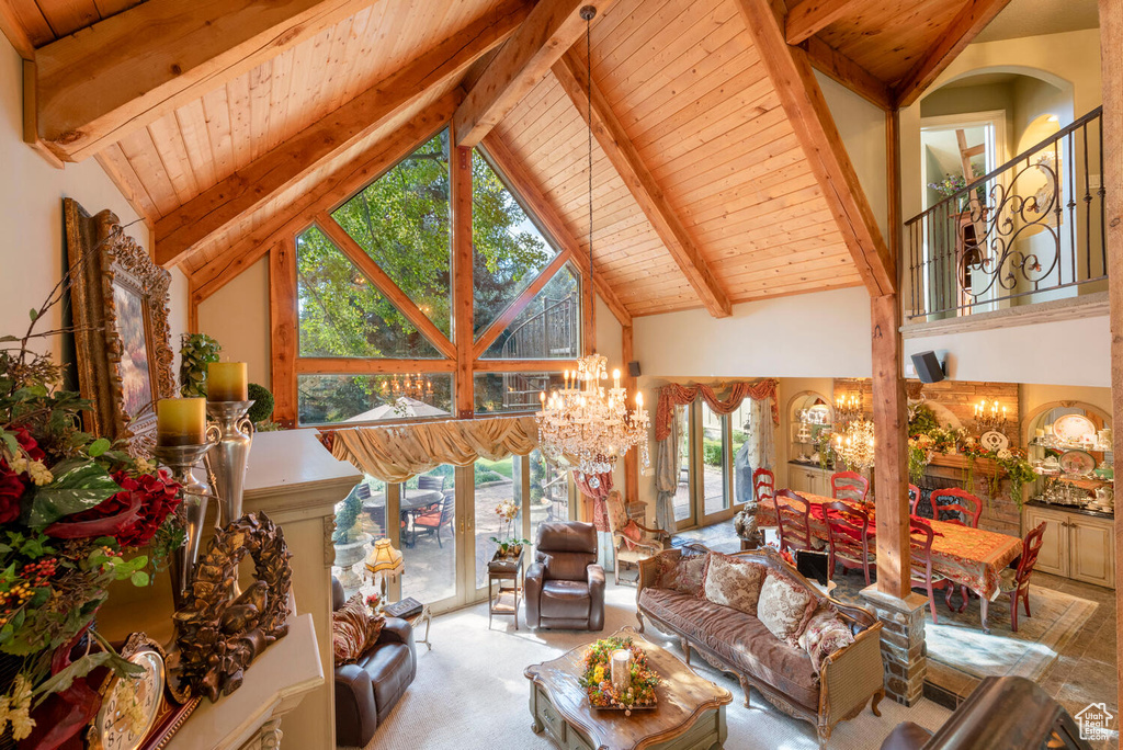 Living room with an inviting chandelier, wood ceiling, high vaulted ceiling, and beam ceiling