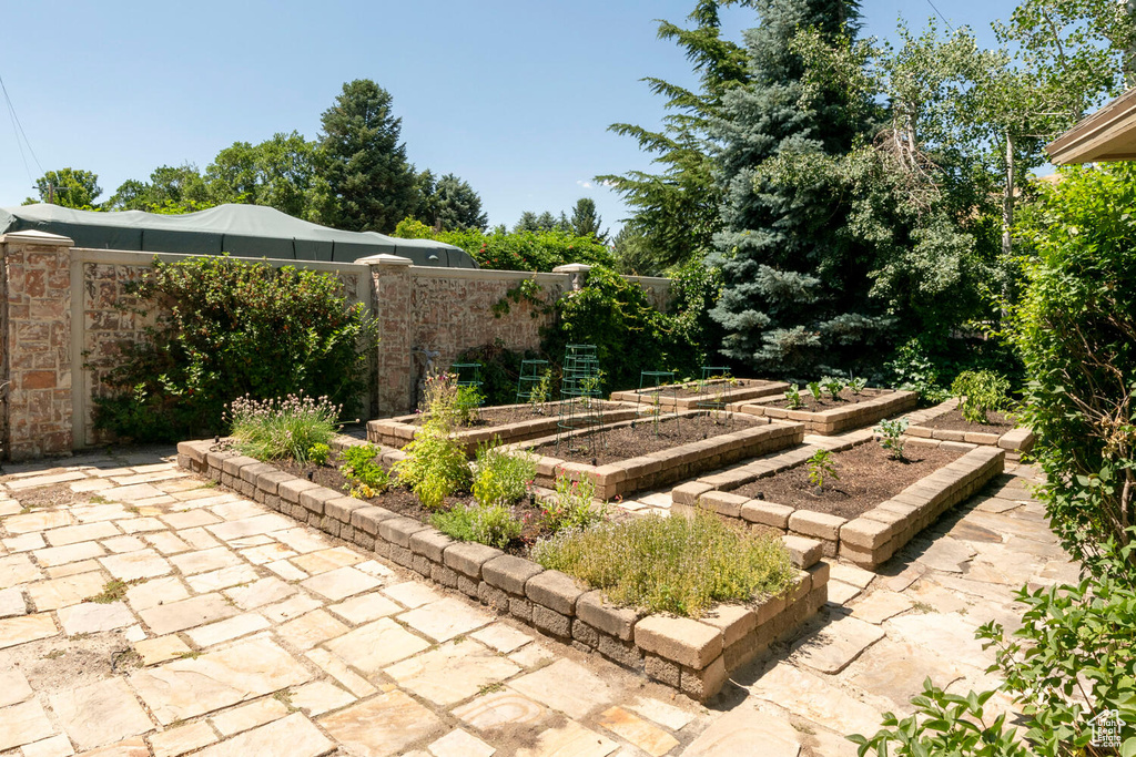 View of yard featuring a patio, a vegetable garden, and fence