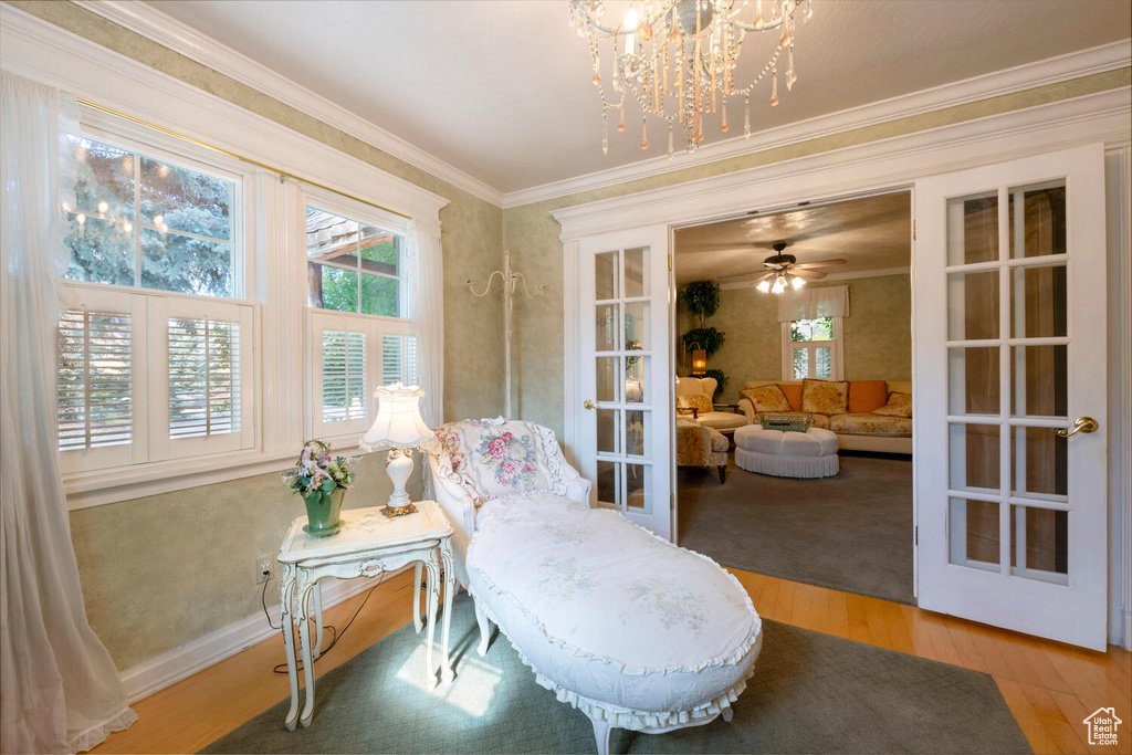 Living area with crown molding, baseboards, wood finished floors, and french doors