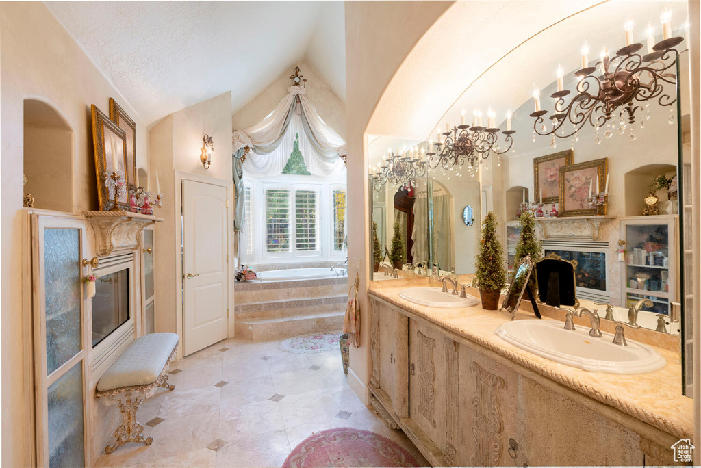 Full bathroom featuring lofted ceiling, a premium fireplace, a sink, and a garden tub