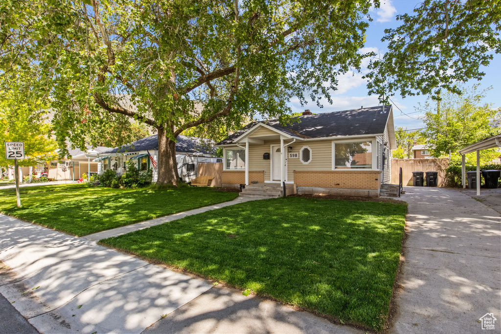 Bungalow-style house with brick siding and concrete driveway